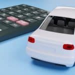 na imagem, uma calculadora e a miniatura de um carro branco