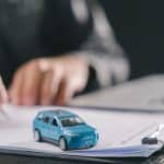 homem assinando documento de compra do carro