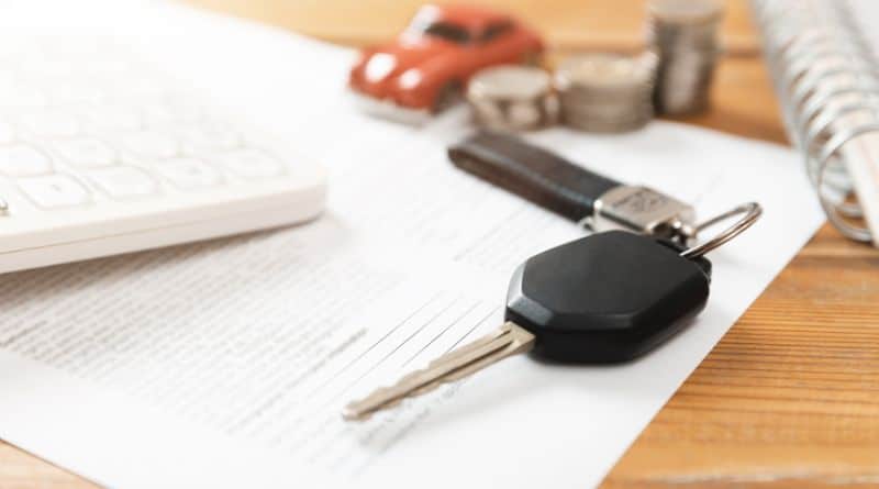 na imagem, um documento, uma chave de carro, uma calculadora, uma miniatura de carro e modeas